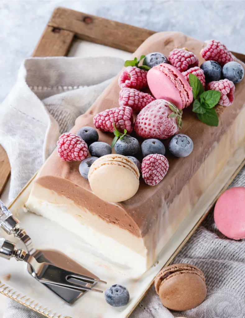 Bûche glacée décorée de fruits rouges et de macarons
