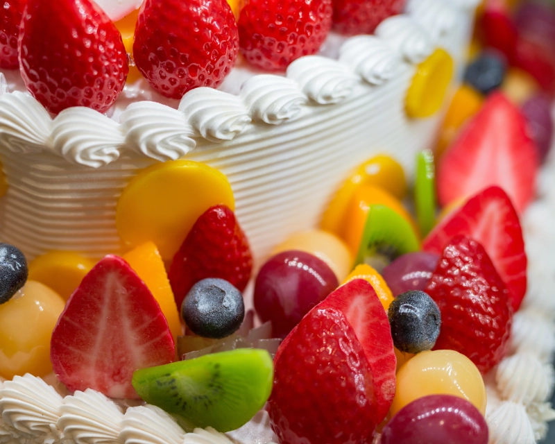 Gâteau aux fruits décoré de fraises, kiwi, myrtilles et raisins